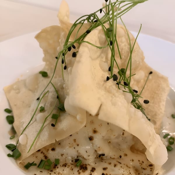 Sontuosa's fusion dish with crispy wonton, creamy sauce, chives, and black sesame seeds.
