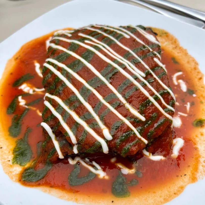Sontuosa's fusion dish: a rectangular entree covered in red sauce, green pesto, and white drizzle.