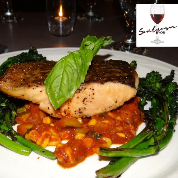 Sontuosa's salmon with crispy skin, broccolini, and a corn and tomato salsa, garnished with basil.
